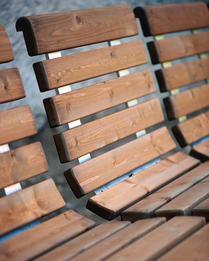 Close up of HAGS wooden benches and chairs.
